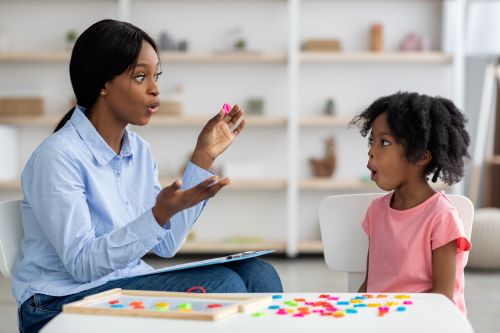 a speech therapist helping a child articulate words